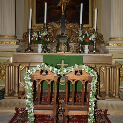 Zwei geschmückte Stühle vor dem Kirchenaltar